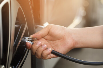 close up hand man car parking a check and inflate the tire fill up the air for safe driving on the...