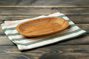 Wooden board with kitchen napkin on dark wooden table