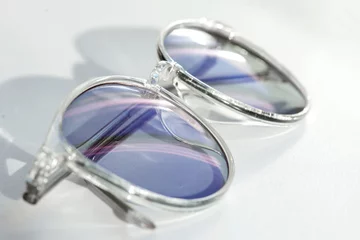 Tafelkleed Stylish pair of eye glasses on a white background. Concept of a correct optics against ametropia. Spectacles with chameleon and tinted lens. © imartsenyuk