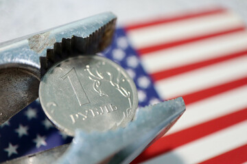 one rouble coin in pincers with usa flag on background - sanctions against russia wallpaper