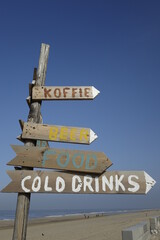 Colourful, handmade wooden signpost for food and beverages ('Koffie': coffee) under blue sky, concept: leisure, holiday, enjoyment (vertical), Noordwijk, South Holland, Netherlands