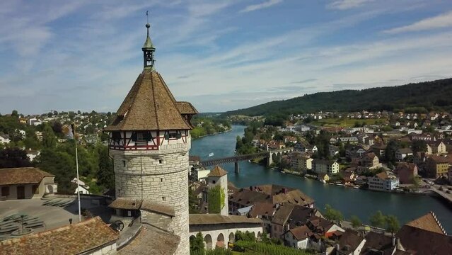 Aerial dolly in of Munot circular fortress on a hill revealing Schaffhausen village and High Rhine river, hills in background, Switzerland