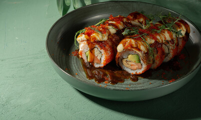 Unamaki with mango and red fish on a green plate among palm branches