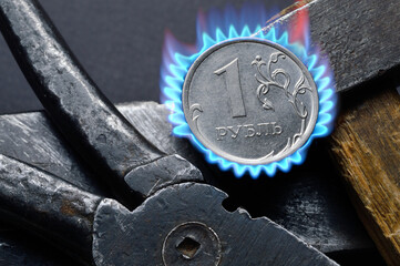 Russian coin with a face value of 1 ruble. and an old working tool. close-up. translation of the...
