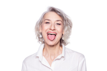 Shot of a beautiful mature woman having fun and teasing sticking out her tongue isolated on white background - obrazy, fototapety, plakaty