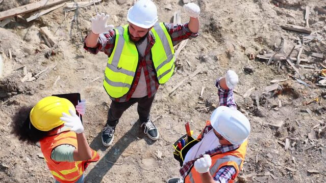 Slow motion VDO. 4K Professional Mechanical Engineer and construction team at house project underconstruction site. Hands meeting together in line. Unity and teamwork concept.