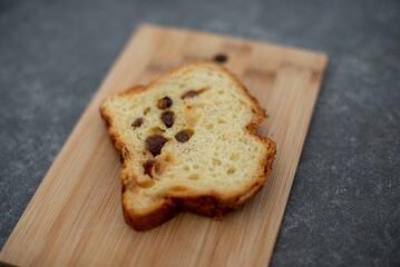 Homemade cake with raisins on a gray concrete background and wooden plate. Top view, close up, selective focus.