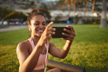 Smiling young woman taking a selfie after yoga practice outside