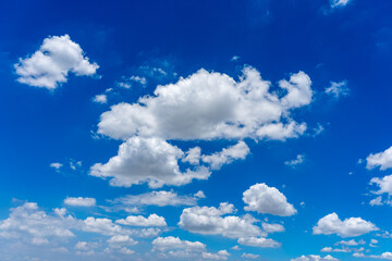 Blue sky background with white cumulus clouds floating