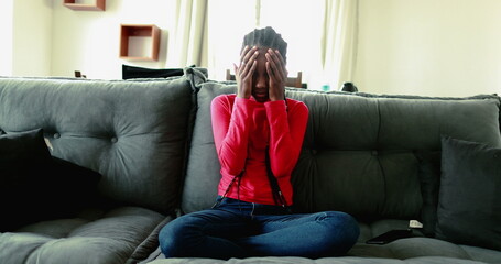 Obraz premium Frustrated anxious teenager adolescent african mixed race girl feeling boredom at home couch