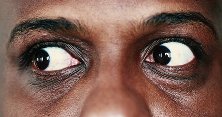 Extreme face close-up, macro eyes of black African man looking sideways