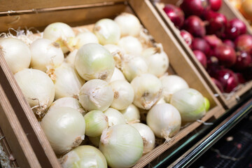 Showcase with onions. Vegetables at supermarket. concept of healthy and organic food consumption