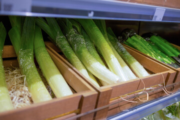 Showcase with leeks. Vegetables at supermarket. concept of healthy and organic food consumption