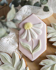 Easter greeting card with Gingerbread cookies - Easter flowers and leaves on wooden plate, selective focus, homemade sweets for spring party