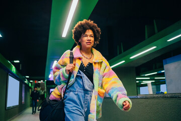 Young black woman commuter walking underground station