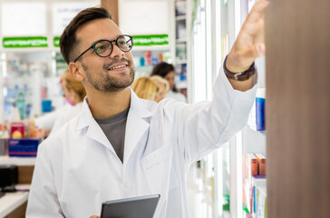 Male pharmacist working in a pharmacy.	 - obrazy, fototapety, plakaty
