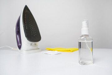 Means for cleaning the iron in a bottle on a white background. Cleaning the sole of the iron, household chemicals