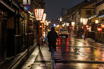 Man on a bicycle in historic Kyoto district at night
