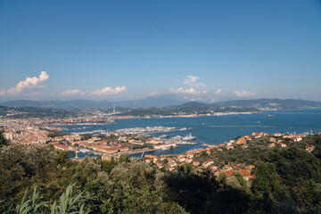Fototapeta na wymiar Sunny panoramic view of the city and the bay, port for ships from the distance. Tourism and transport. Rest and travel. Summe day.
