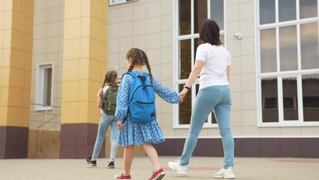 back to school. mom and daughter a go hand in hand to school for lesson. education training support concept lifestyle. child walk to school with a backpack. daughter mom rush to school. family day