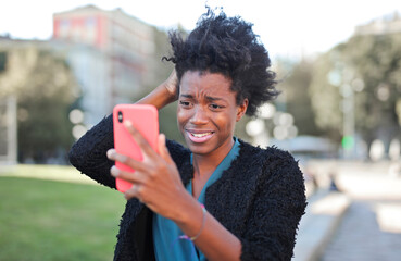 young woman looks at her smartphone disappointed
