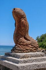 Fototapeta premium A tropical fish sculpture statue of a large tropical fish at the entrance to popular Cristo Rei beach in Dili, Timor Leste