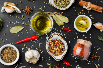 Fototapeta na wymiar Olive oil, herbs and spices on black background