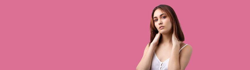Naklejka premium Beautiful smiling woman with clean skin, natural make-up and white teeth on a Pacific Pink background