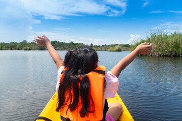 Asian girl life jacket orange color raise the hand to nature on the boat travel. Clear weather and...