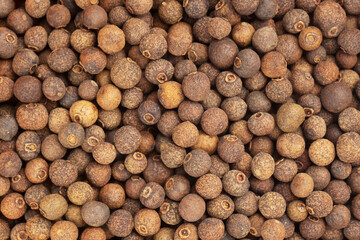 Spice Allspice brown background. Macro. Flat lay. Diet concept