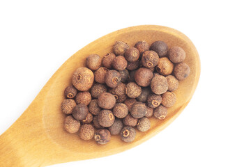 Spice Allspice in wooden spoon diagonally on white background. Flat lay. Brown color. Indian cuisine concept