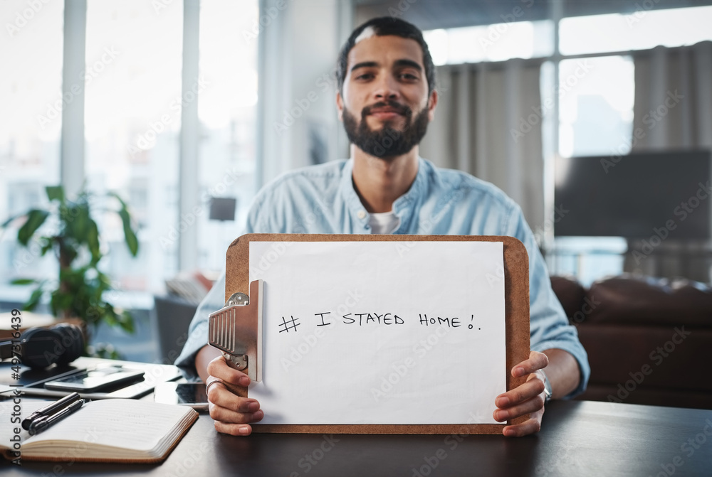 Poster i made a difference by staying home. shot of a young man holding up a clipboard with i stayed home w