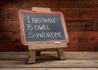 IBS - irritable bowel syndrome, white chalk handwriting on a retro slate blackboard, medical...