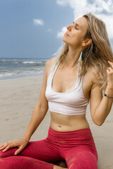 Portrait of a beautiful young woman meditating at the beach enjoying summer