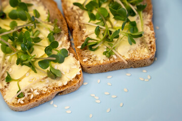 Set sandwiches for breakfast. Sandwiches with micro greens on blue plate on wooden background, tasty and fresh organic food healthy breakfast snack concept