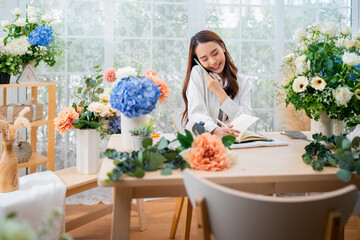 taking order florist working from home,young asian florist making list from client order to arrange flower bouqet vase delivery, Flower design store. happiness smiling young lady making flower vase 
