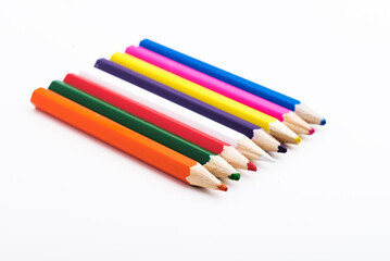 several colored pencils on a white background.