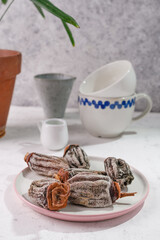 dried persimmon on a plate on a white kitchen table. Next to the kitchen utensils. Eco dried fruits