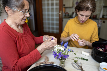Mother Senior Woman And Mid Adult Daughter Woman Preparing Easter Decorations Together