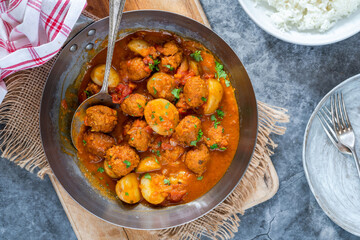 Sausage meatballs and potatoes in curry sauce with rice