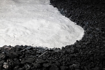 Black and white background. Coal and white bulk material.