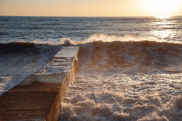 The sea wave. Sunset in the sea. The power of the elements.