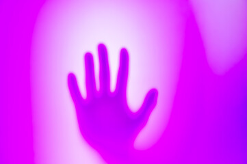 Fototapeta na wymiar Ghost shadow of hand behind frosted glass, Violence, fear, horror halloween trapped and panic concept, faceless person, Abstract blur hands silhouettes, blurry and soft focus, purple, violet a magenta