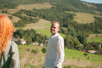 Young happy couple is resting surrounded by mountains.