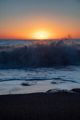 The sea wave. Sunset in the sea. The power of the elements.