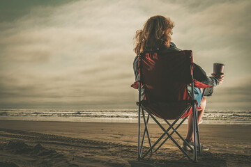 Woman with Coffee in Her Hand Enjoying Free Time on a Beach