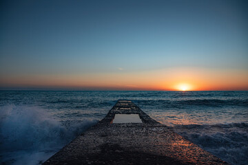 Fototapeta na wymiar The coastline. Sea sunset. The Black Sea. Concrete pier. Twilight.