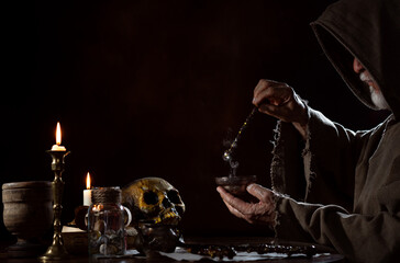 Medieval magician with magic wand mixing elixir