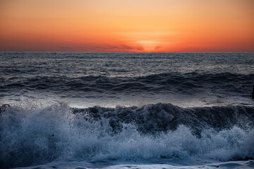 The sea wave. Sunset in the sea. The power of the elements.