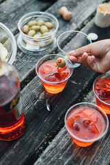 Making aperol spritz cocktails outdoors on picnic table